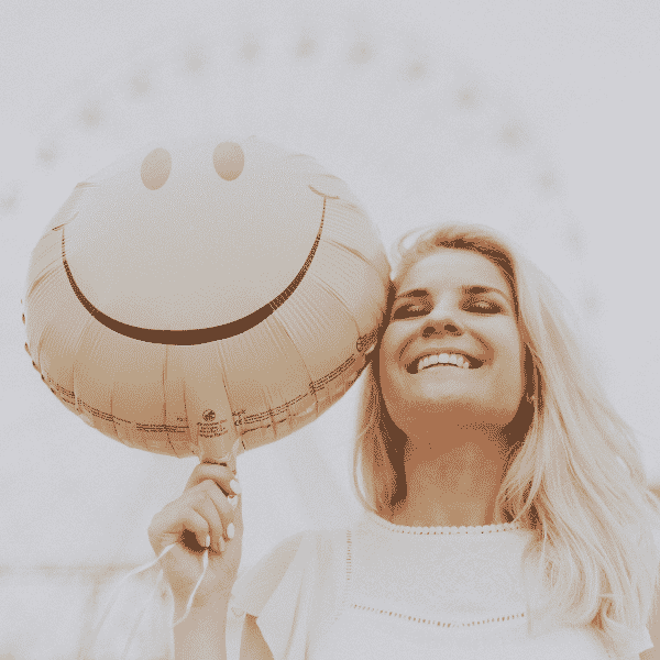 Close de cima para baixo em mulher feliz segurando balão smile